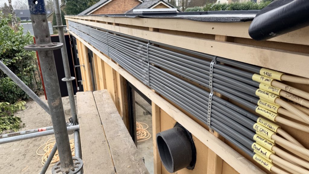 Aanleg van de installatieleidingen tijdens de bouw.