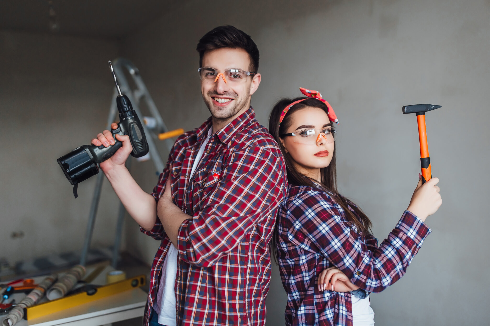 Twee doe-het-zelvers met gereedschap en veiligheidsbrillen